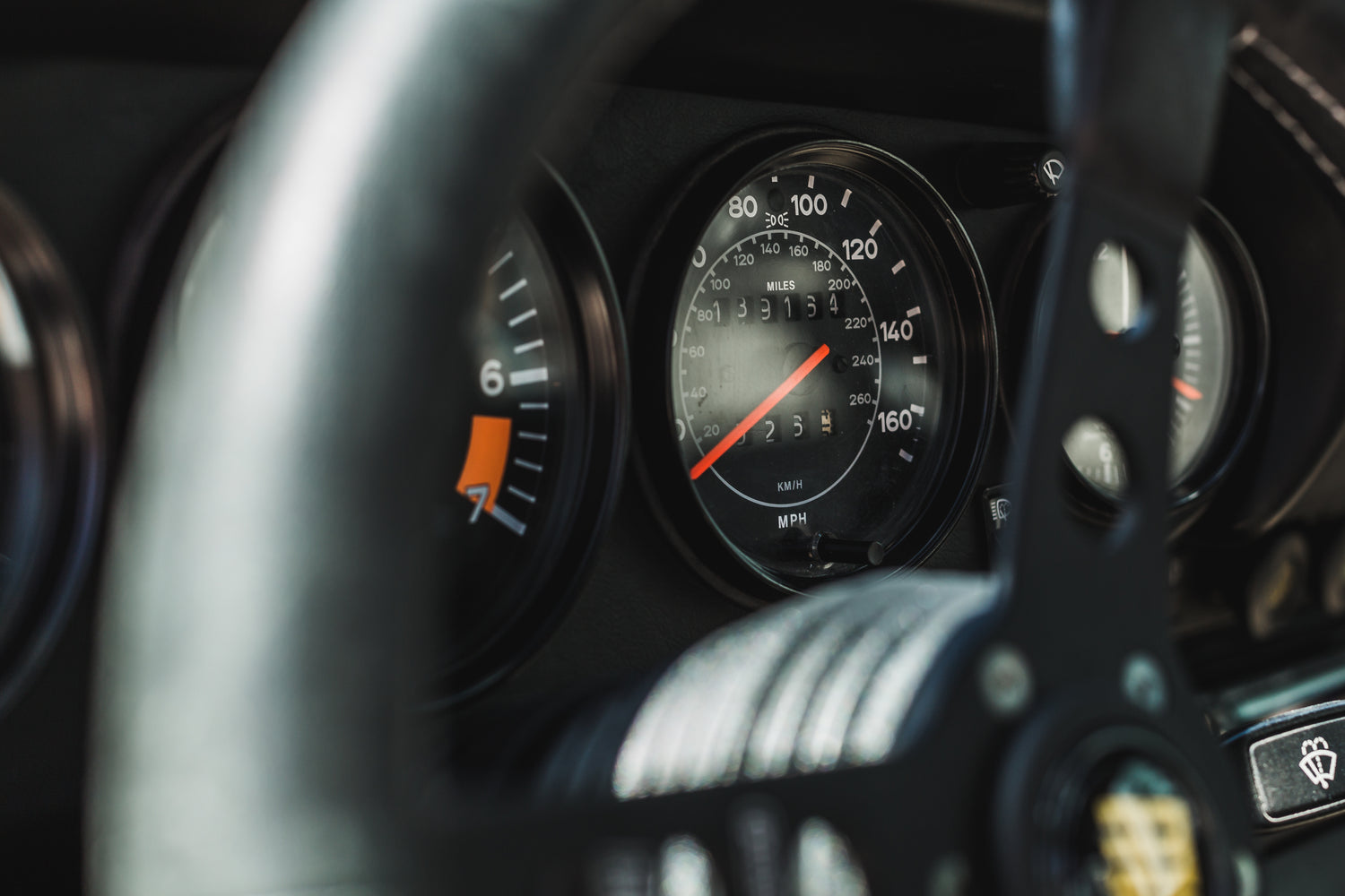 Fotografía del volante de un coche donde se visualiza el cuadro de instrumentos con el velocímetro en primer término.